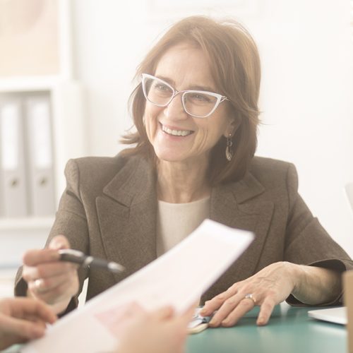Smiling personal health coach sitting in an office and talking to a woman