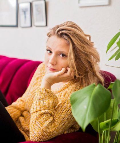 Portrait of beautiful woman sitting on sofa at home